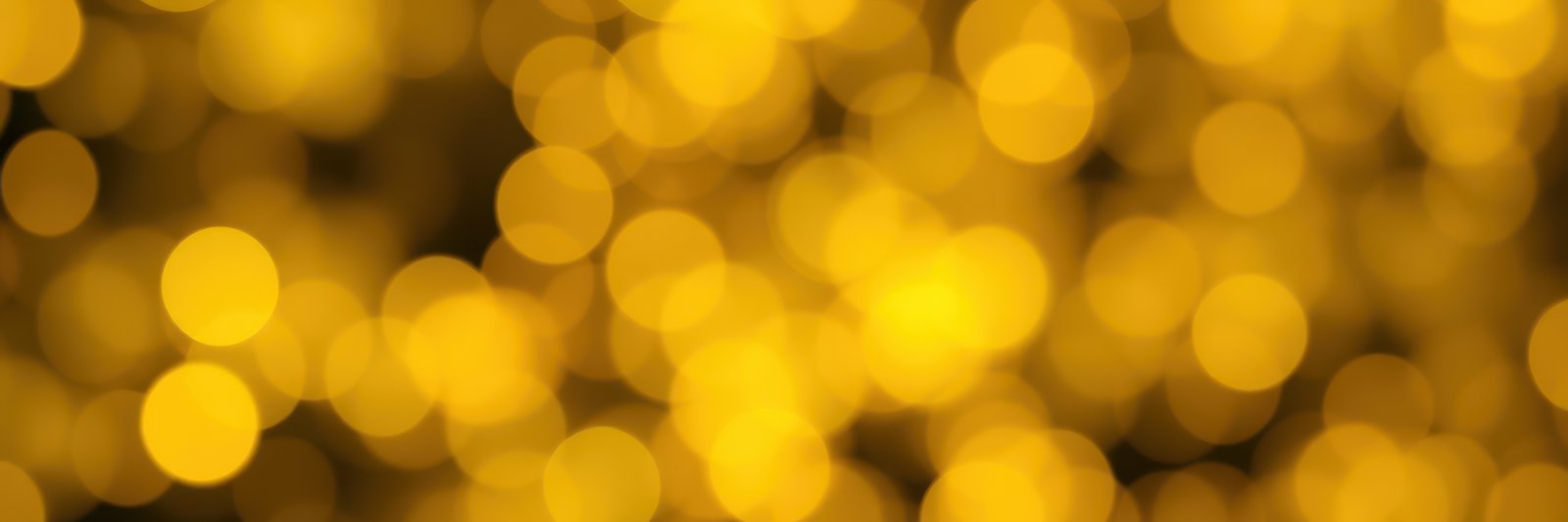 Bright golden bokeh lights create a festive atmosphere during a nighttime celebration or event